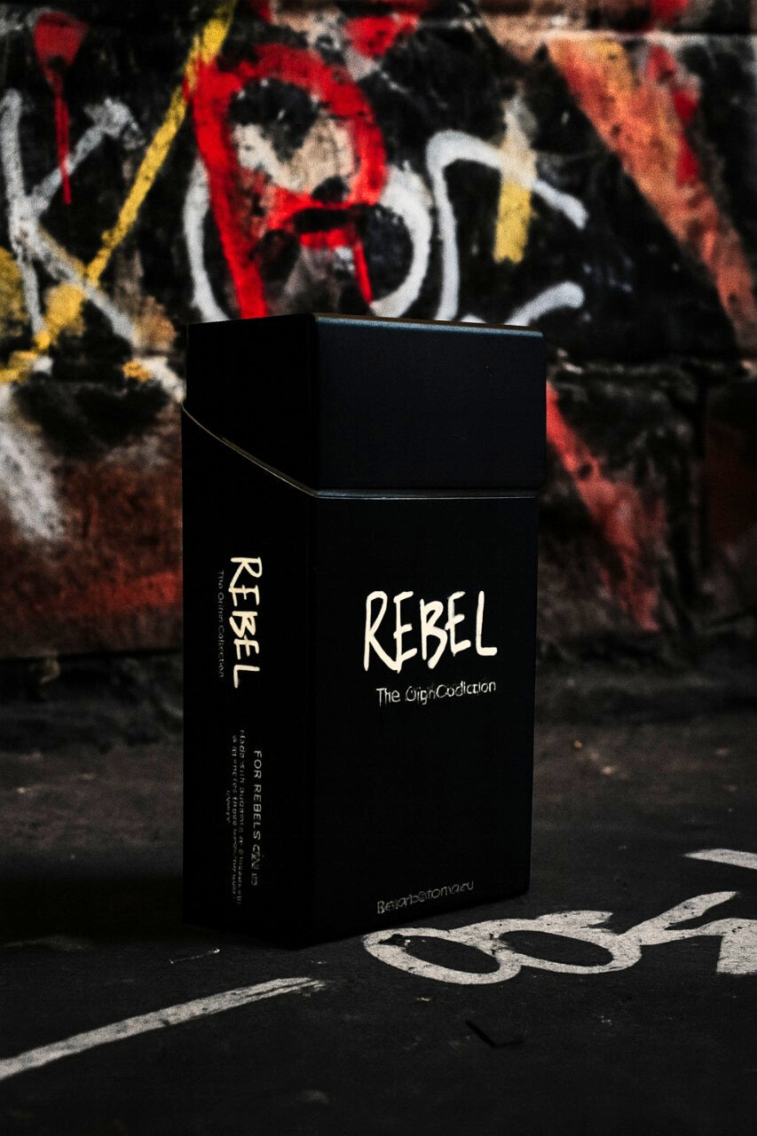 Black 'REBEL' cigarette pack against a graffiti-covered wall.